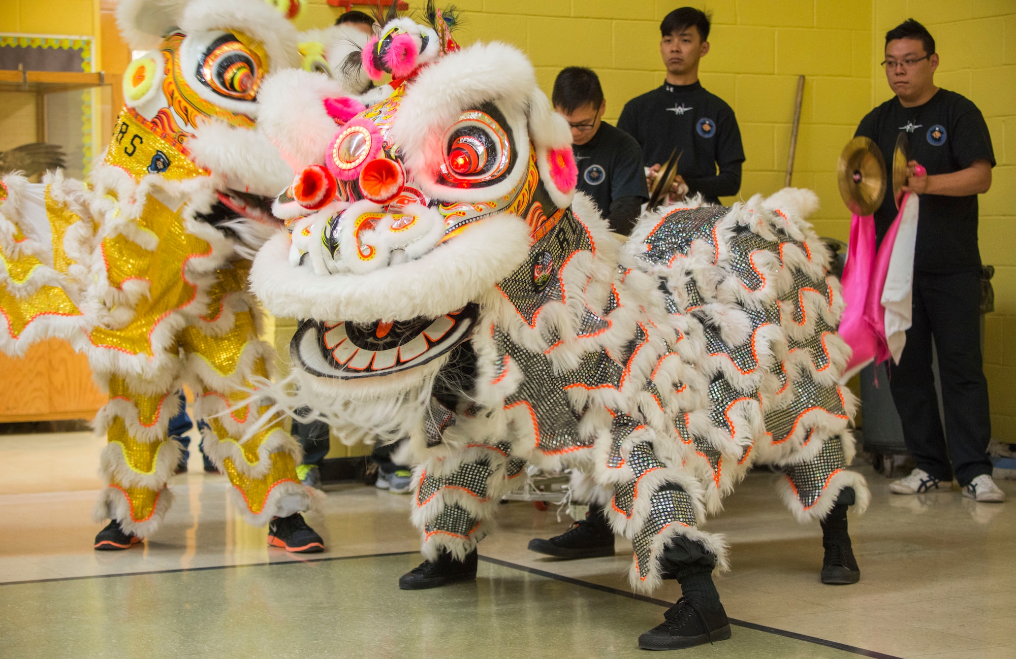 Two traditional lion mascots work their way across the gym floor entertaining the students of Stephensen Elementary at Mountain Home Air Force Base, Idaho Feb. 23, 2015. The students were taken by surprise by the sound of drums behind them when the lions leapt through the door. (U.S. Air Force photo by Airman Connor J. Marth/RELEASED)