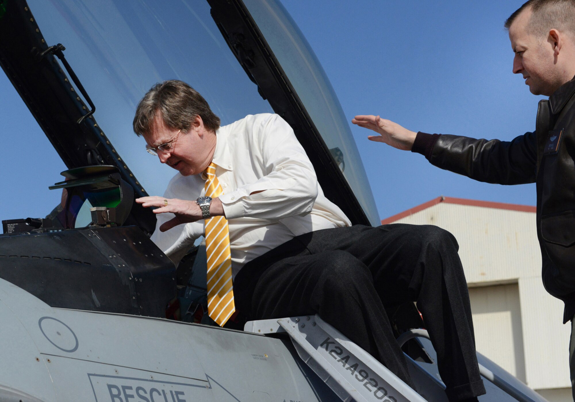 Maj. Chris Wells explains proper and safe entry into an F-16 Fighting Falcon cockpit to Tulsa Mayor Dewey F. Bartlett, Jr. during a visit February 25, 2015 at the Tulsa Air National Guard base, Tulsa, Okla. The mayor was hosted by 138th leadership as a community outreach event aimed at fostering good relations and educating local leaders on the mission of the wing.