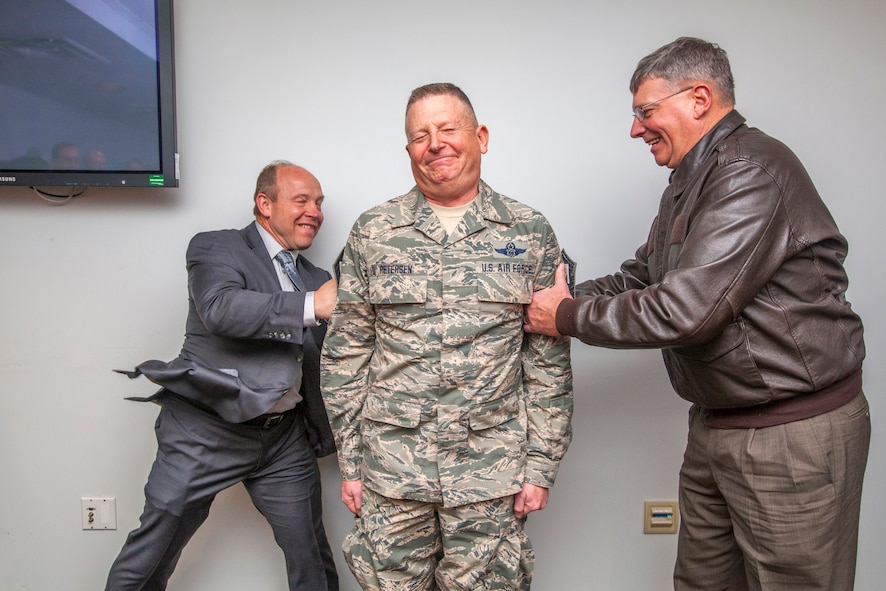 Senior Master Sgt. Raymond Petersen, center, superintendent, 108th Global Mobility Squadron, 108th Wing, New Jersey Air National Guard, is promoted to chief master sergeant by his brother, retired Brig. Gen. Robert Petersen, right, and retired Col. Brian Bradner Feb. 26, 2015, at the Wing's headquarters at Joint Base McGuire-Dix-Lakehurst, N.J. (U.S. Air National Guard photo by Master Sgt. Mark C. Olsen/Released)