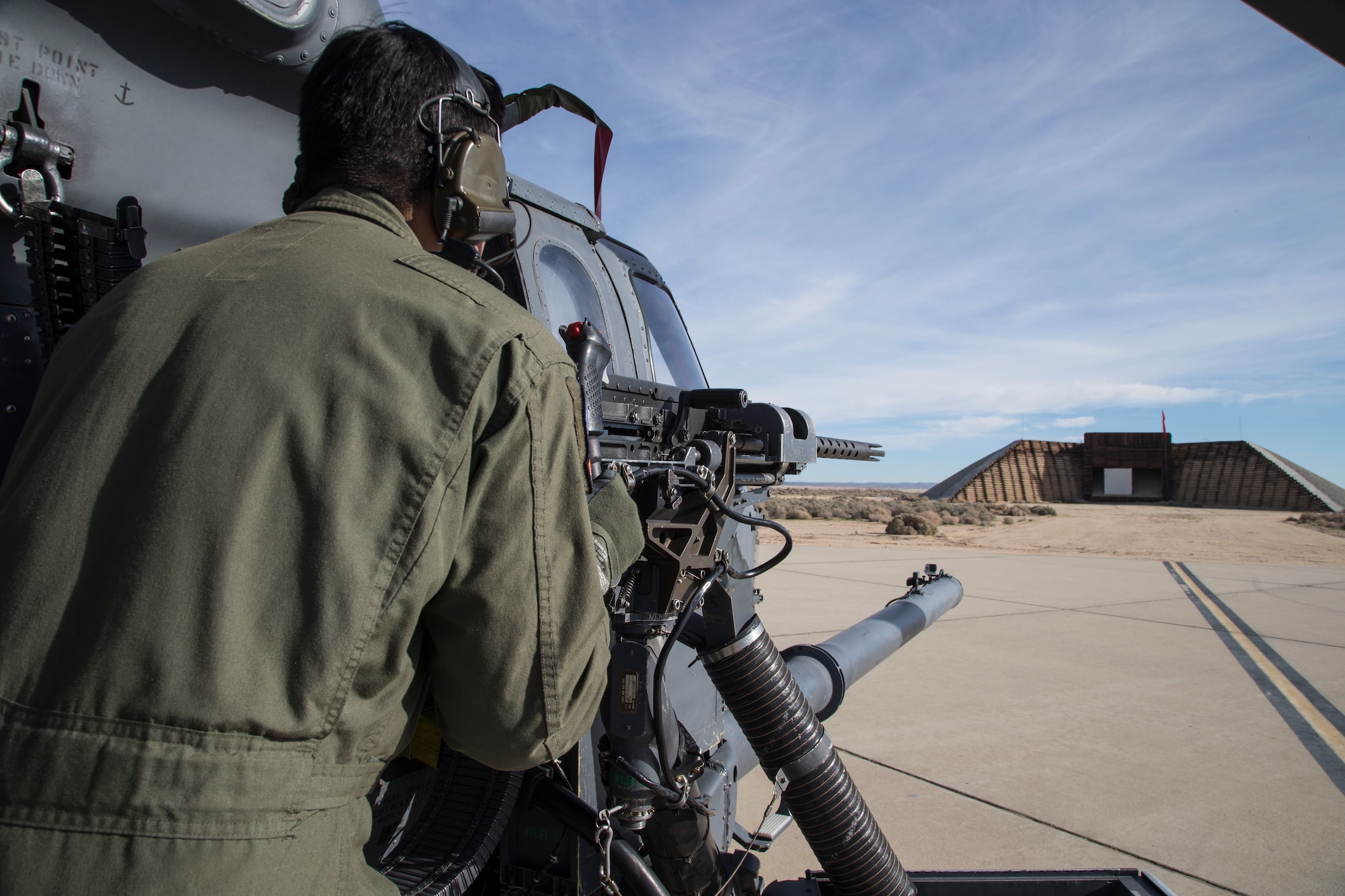 A gunner from the Combat Search and Rescue Combined Test Force fires at a canvas target positioned on the Gun Harmonizing Range during a baseline ballistics test held Feb. 11. The objective of tes test effort was to baseline the ballistic dispersion of the GAU-18 .50 caliber machine gun mounted to the HH-60G Pave Hawk via the External Gun Mount System (EGMS) and to collect barrel temperatures during firing. (U.S. Air Force photo by Bobbi Zapka)