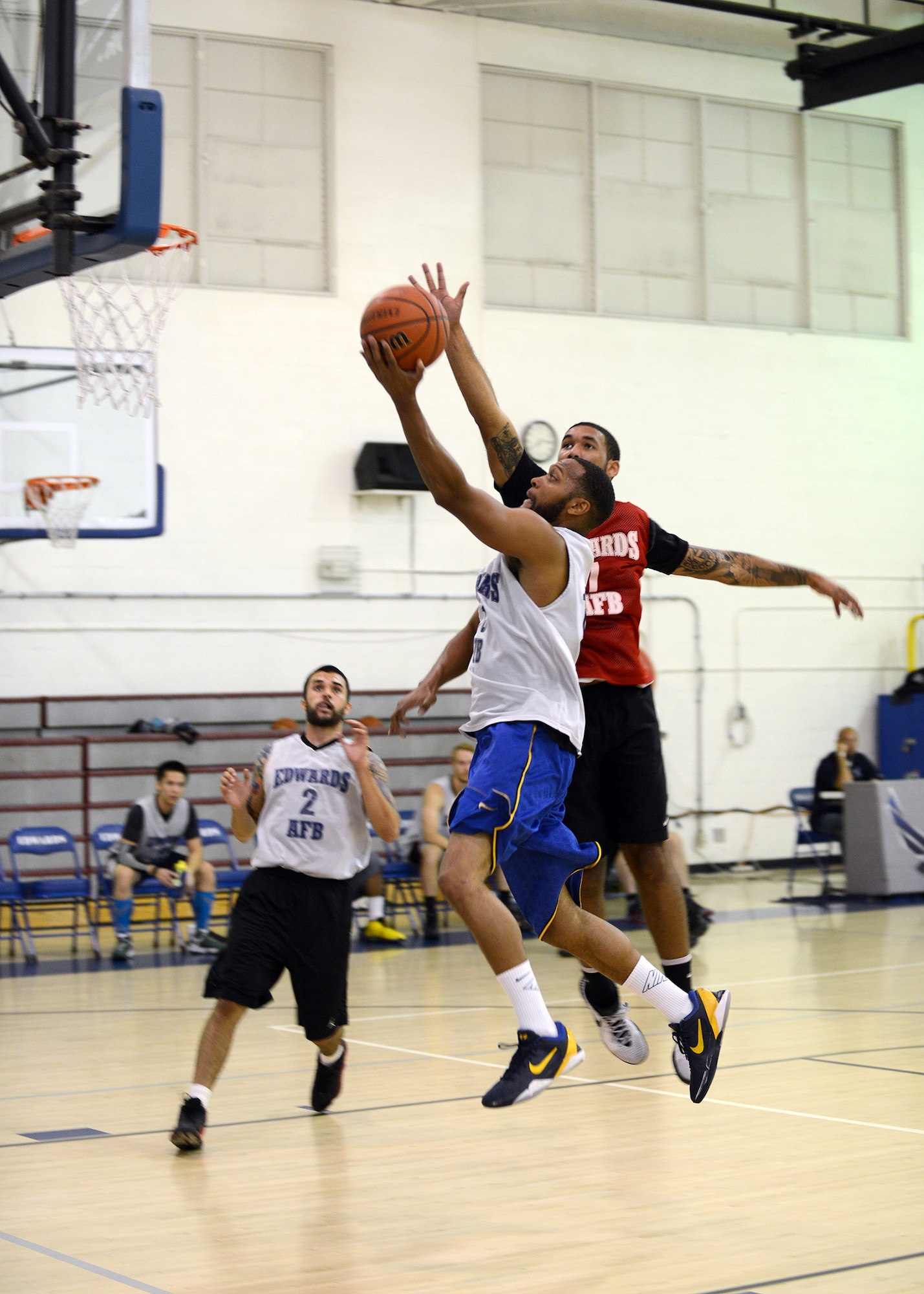 Sidney Melvin, from the East team, drives in for a layup against West defender, Jadrien Wiser, during the base's All-Star basketball game held Feb. 18 at the Rosburg Fitness Center. The final score of the game was East 81- West 71. (U.S. Air Force photo by Jet Fabara)
