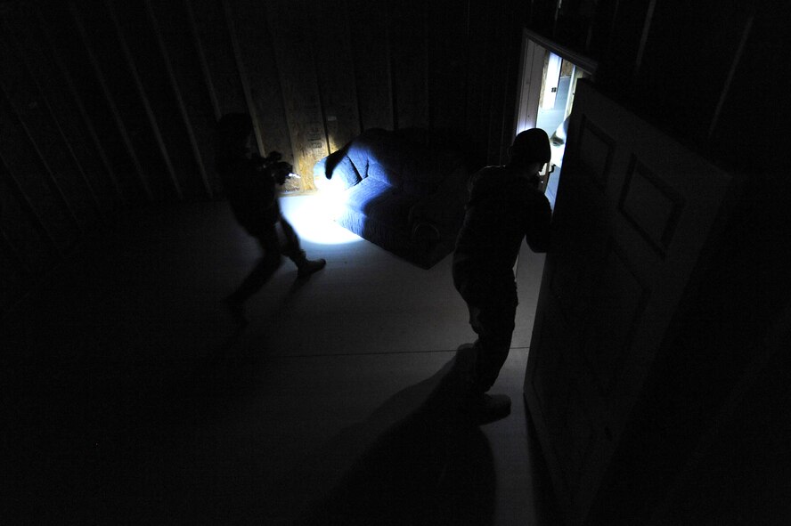 Airmen assigned to the 4th Security Forces Squadron clear a building during monthly training Feb. 11, 2015, at the range training complex on Seymour Johnson Air Force Base, North Carolina. The wooden shoot house features a movable wall system, which allows the interior layout to be changed to vary clearing strategies and improve their skills. (U.S. Air Force photo/Airman 1st Class Aaron J. Jenne)