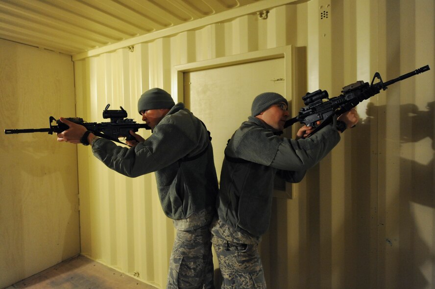 Senior Airmen Willie Gibson (left) and Donald Suver, 4th Security Forces Squadron patrolmen, cover a doorway and stairwell respectively, while clearing a building during monthly training Feb. 11, 2015, at the range training complex on Seymour Johnson Air Force Base, North Carolina. The training facility includes three buildings with interior stairwells, balconies and observation catwalks. (U.S. Air Force photo/Airman 1st Class Aaron J. Jenne)
