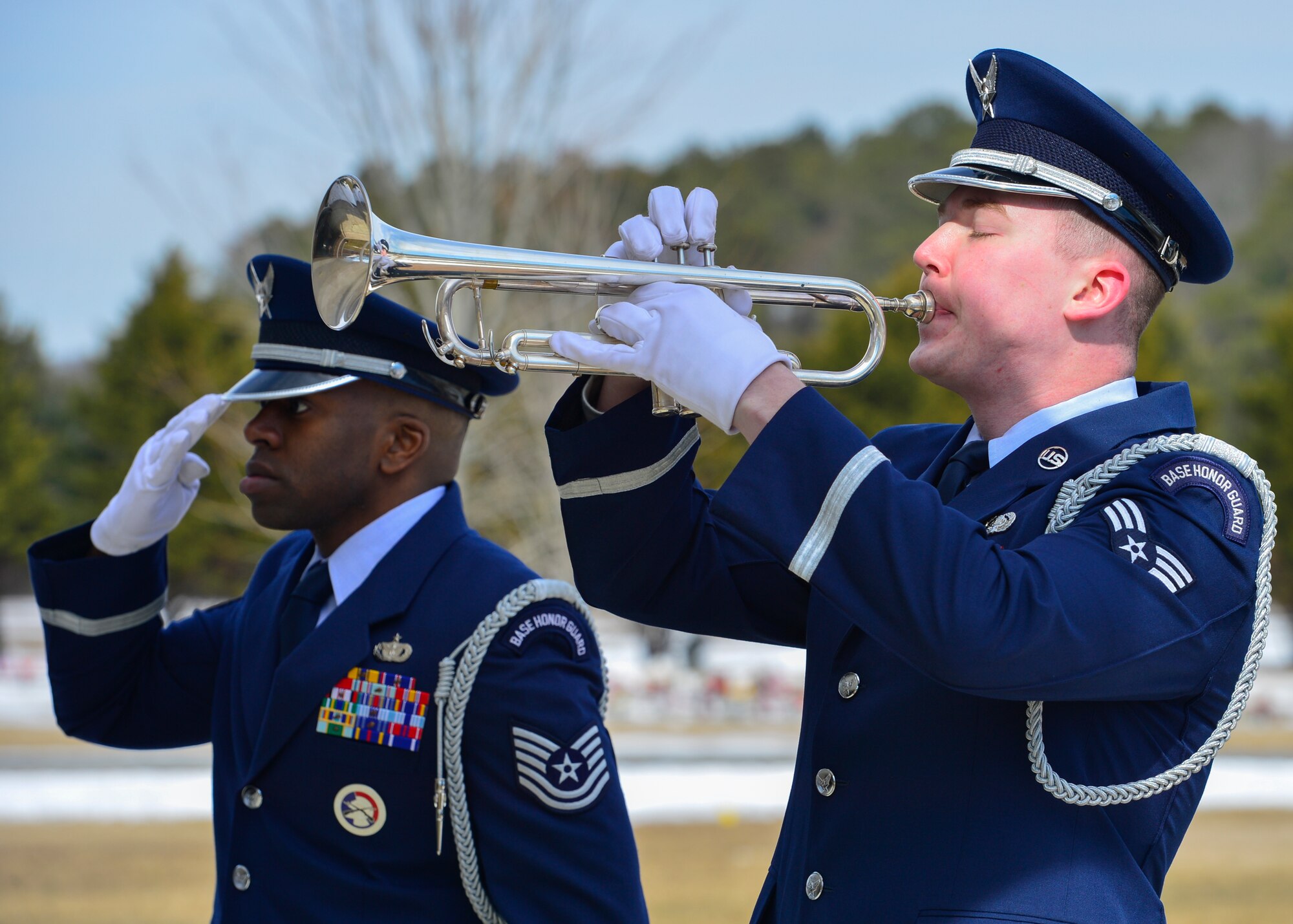 Tech. Sgt. Isaiah Martin, Dover Air Force Base Honor Guard NCO in charge, salutes as Senior Airman Gene Kellenberger, Dover AFB Honor Guard member, plays “Taps” on a bugle during a funeral Feb. 25, 2015, at the Delaware Veterans Memorial Cemetery in Millsboro, Del. The funeral was for Jay Unterkofler, a U.S. Air Force retired master sergeant and a City of Dover Police retired sergeant. (U.S. Air Force photo/Airman 1st Class Zachary Cacicia)