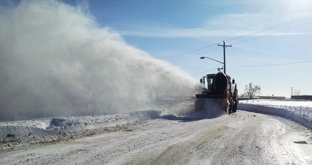 Pegasus Support Services, the snow removal team for Niagara Falls Air Reserve Station, blows snow into a vacant field off of an access road on base, February 25, 2015. Snow accumulation for the Western New York region has been so extreme that plows have run out of places on base to dump the snow. (Courtesy Photo) 