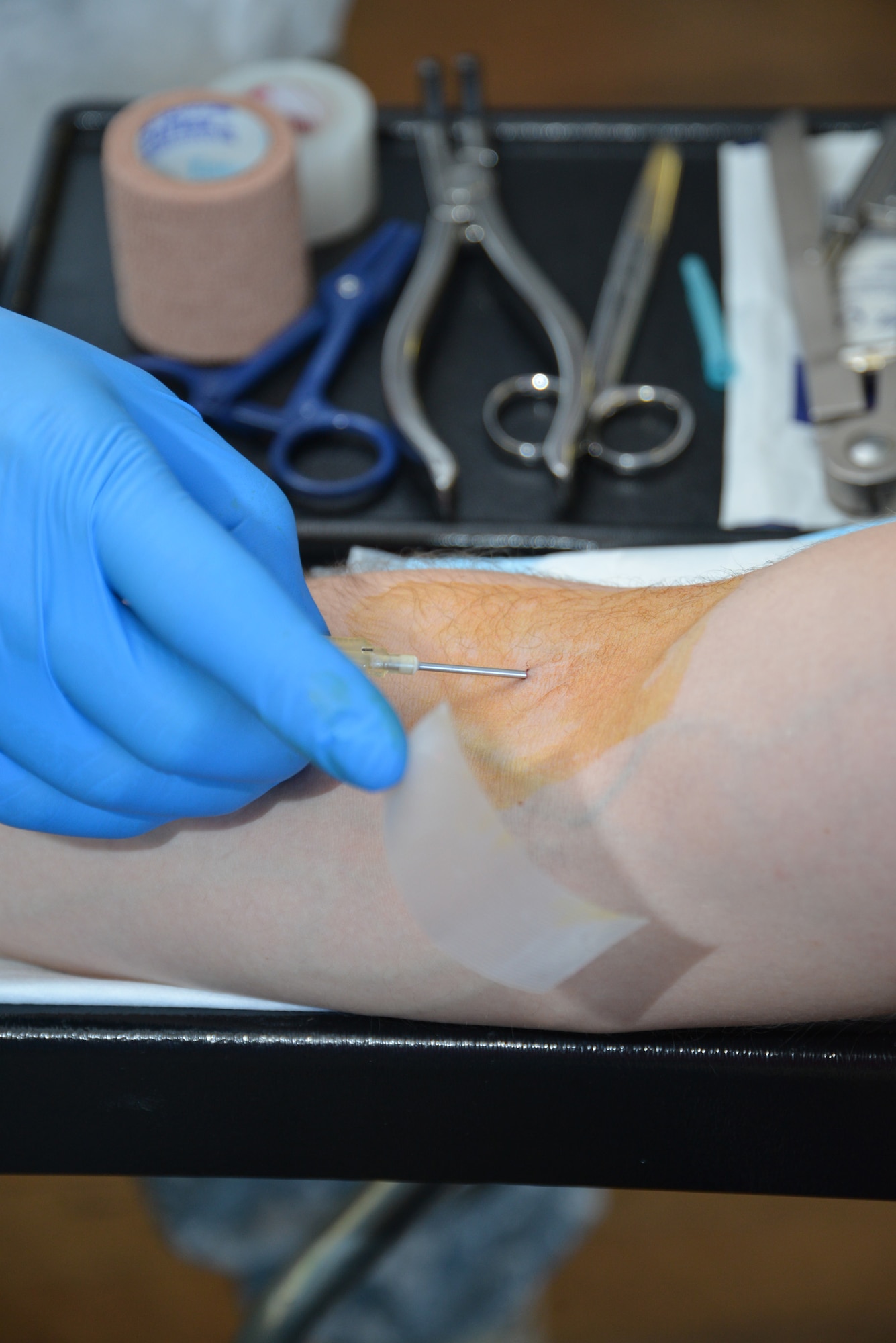 A 5501st U.S. Army Hospital laboratory technician from the Landstuhl Regional Medical Center, Germany, prepares to collect blood from a U.S. service member at a blood drive Feb. 25, 2015, on RAF Mildenhall, England. Team Mildenhall members donated 82 units of blood in less than 10 hours. (U.S. Air Force photo by Karen Abeyasekere/Released)