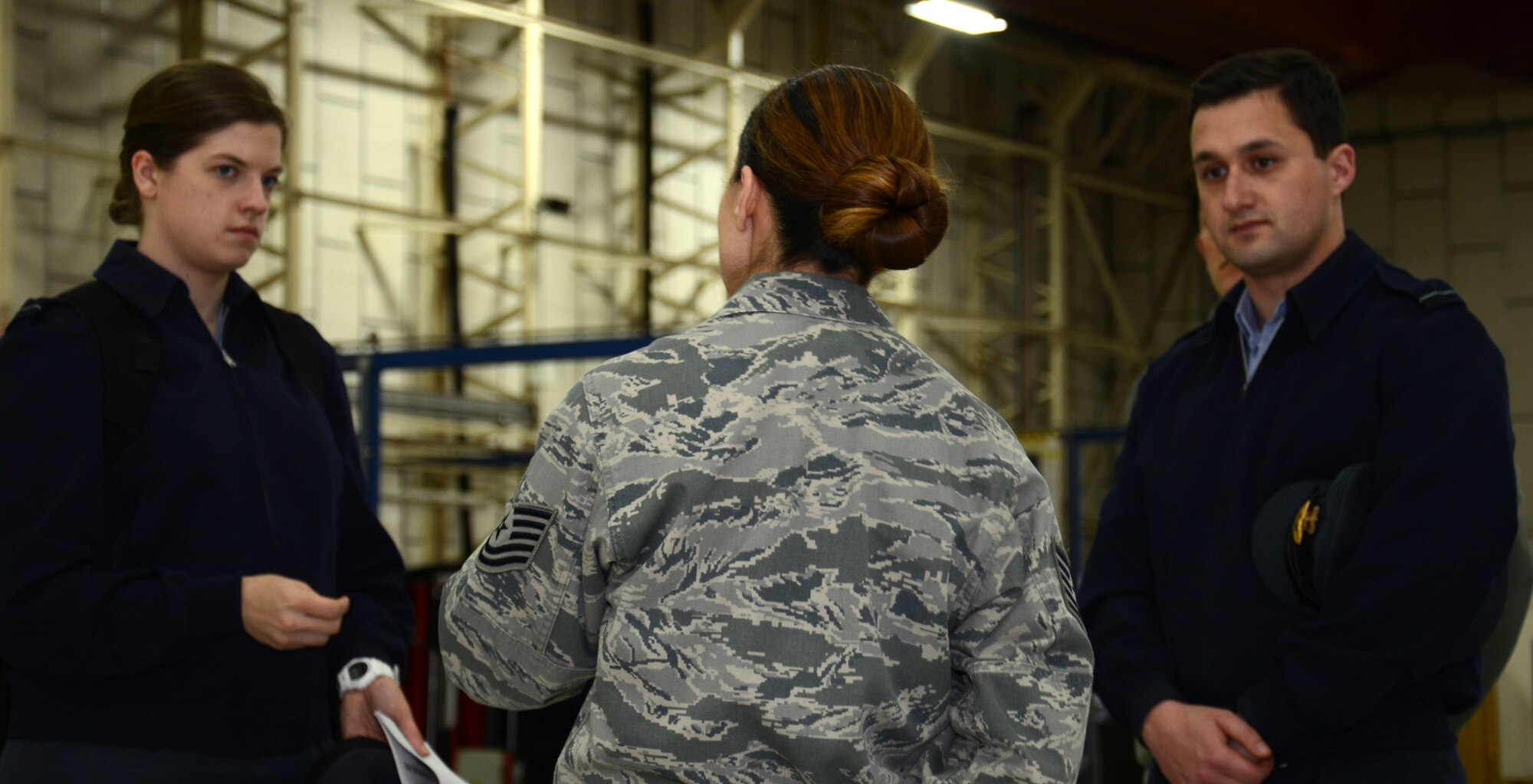 U.S. Air Force Tech. Sgt. Amy Chandler, center, 100th Logistics Readiness Squadron Vehicle Maintenance NCO in charge of general purpose vehicles from New Orleans, La., briefs Flying Officer Victoria Sisson, left, and Flying Officer Graham Macalister, during a tour of her squadron Feb. 24, 2015, on RAF Mildenhall, England. Royal Air Force Logistics officers visited with members of the 100th LRS during a site tour to further improve relations between the two nations. (U.S. Air Force photo by Gina Randall/Released)