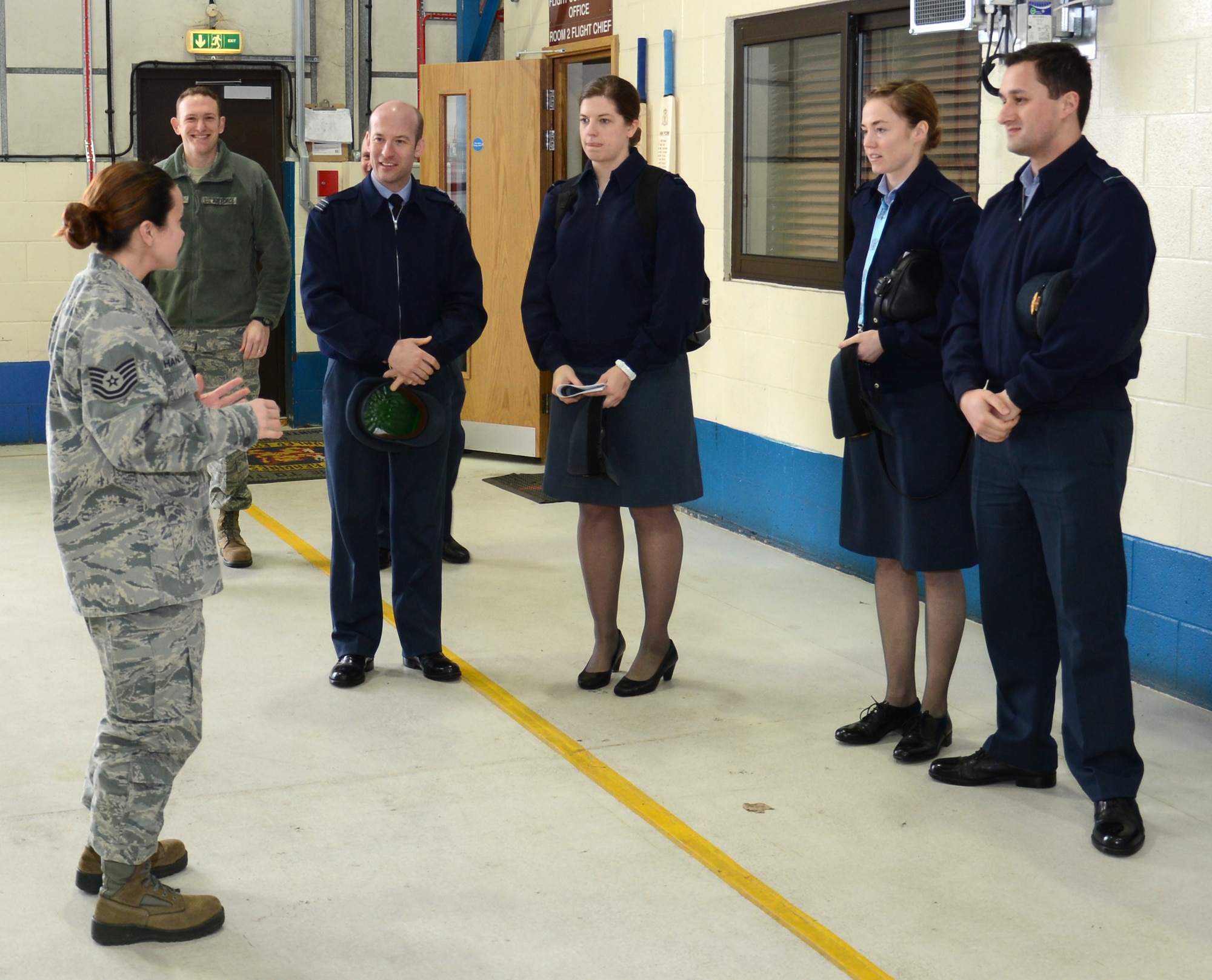 U.S. Air Force Tech. Sgt. Amy Chandler, left, 100th Logistics Readiness Squadron Vehicle Maintenance NCO in charge of general purpose vehicles from New Orleans, La., briefs Royal Air Force Logistics officers during a tour of the 100th LRS Feb. 24, 2015, on RAF Mildenhall, England. RAF Logistics officers visited with members of the 100th LRS during a site tour to further improve relations between the two nations. (U.S. Air Force photo by Gina Randall/Released)