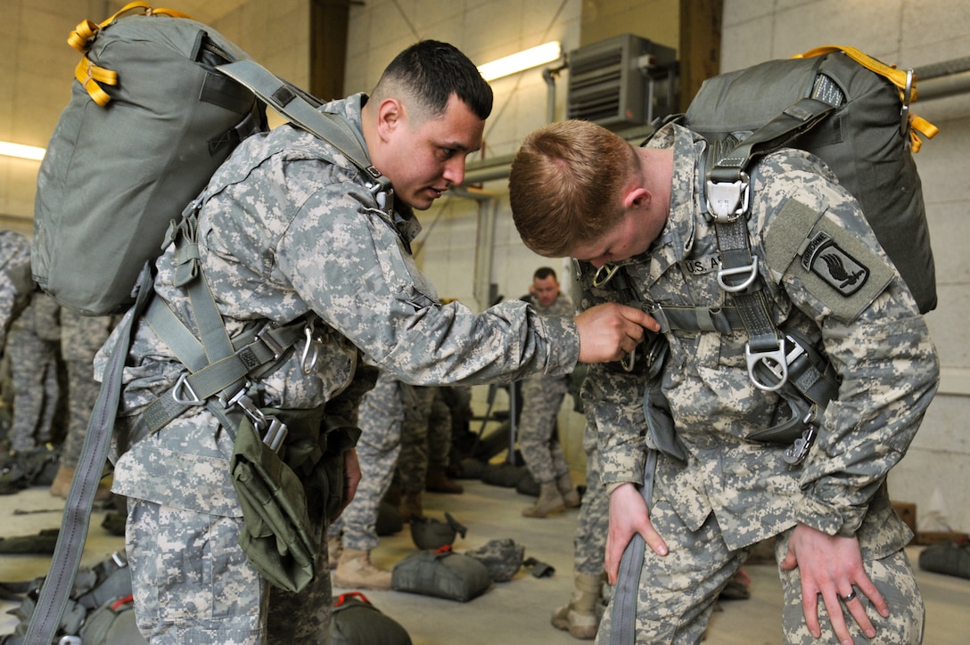 U.S. Army paratroopers check each other's equipment before an airborne mission on the 7th Army Joint Multinational Training Command's Grafenwoehr Training Area in Germany, Feb. 25, 2015. 