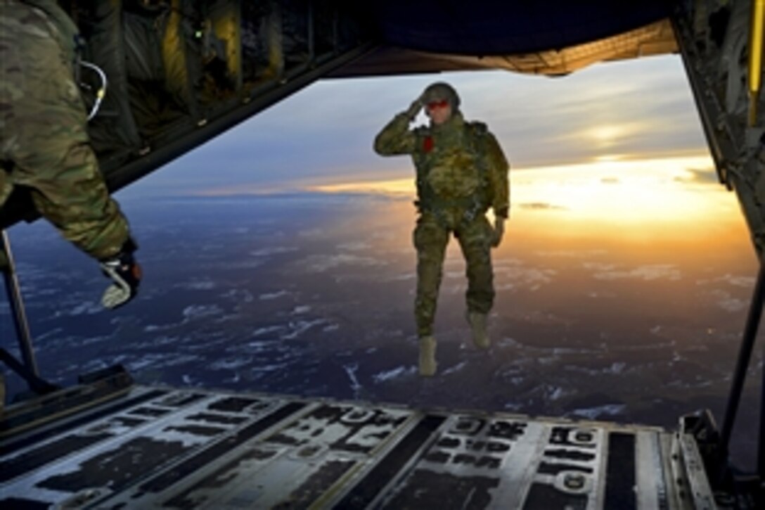 A U.S. soldier salutes his fellow soldiers while jumping from a C-130 Hercules aircraft over a drop zone in Germany, Feb. 24, 2015. The soldier is assigned to 1st Battalion, 10th Special Forces Group.