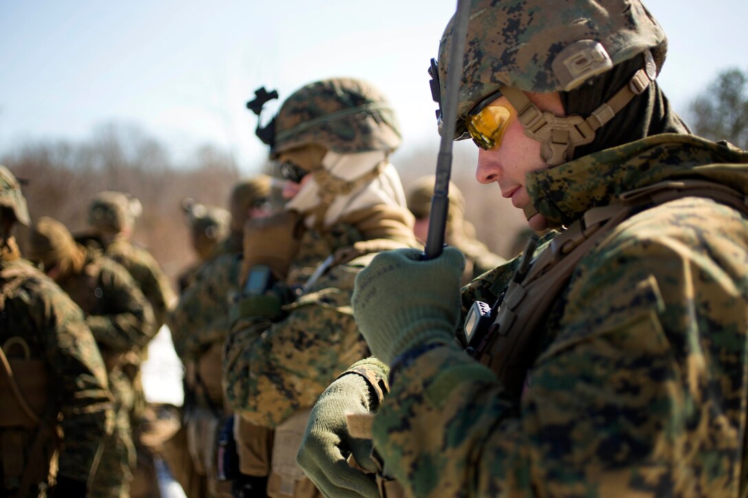Marine Corps Sgt. Justin R. Kelley, right, secures his PRC-152 multiband radio onto his plate carrier before conducting a patrol during a deployment exercise on Marine Corps Base Quantico, Va., Feb. 18, 2015. Kelley is a squad leader assigned to the 2nd Marine Division's Alpha Company, 1st Battalion, 8th Marine Regiment. The exercise focused on stability operations and training missions.