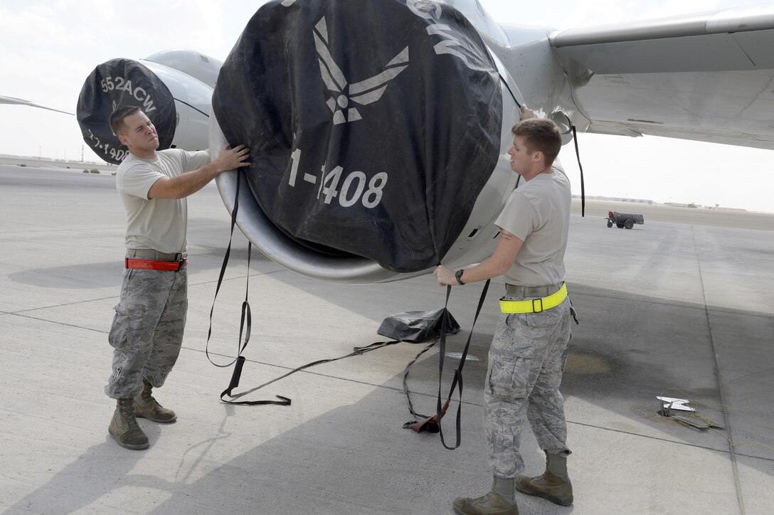 Staff Sgt. Derek, left, aerospace propulsion craftsman, and Senior Airman Travis, surveillance and radar technician, help recover an E-3 Sentry airborne warning and control system aircraft as they place a cover over the engine at an undisclosed location in Southwest Asia Feb. 24, 2015. AWACS provides situational awareness of friendly, neutral and hostile activity, command and control of an area of responsibility, battle management of theater forces, all-altitude and all-weather surveillance of the battle space, and early warning of enemy actions during joint, allied, and coalition operations. Derek is currently deployed from Tinker Air Force Base, Okla., and is a native of Waterboro, Maine. Travis is currently deployed from Tinker AFB, Okla., and is a native of Snohomish, Wash. (U.S. Air Force photo/Tech. Sgt. Marie Brown)