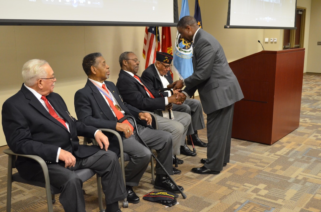 Stan Sims, director of Defense Security Service, presents DSS coins to four Montford Point Marine veterans at the Russell Knox Building on Tuesday. From left to right, the veterans are former recruit Stanley Tapscott, retired Gunnery Sgt. Richard Walker, retired Staff Sgt. Johnny Cody, and retired Master Gunnery Sgt. Carroll Braxton.