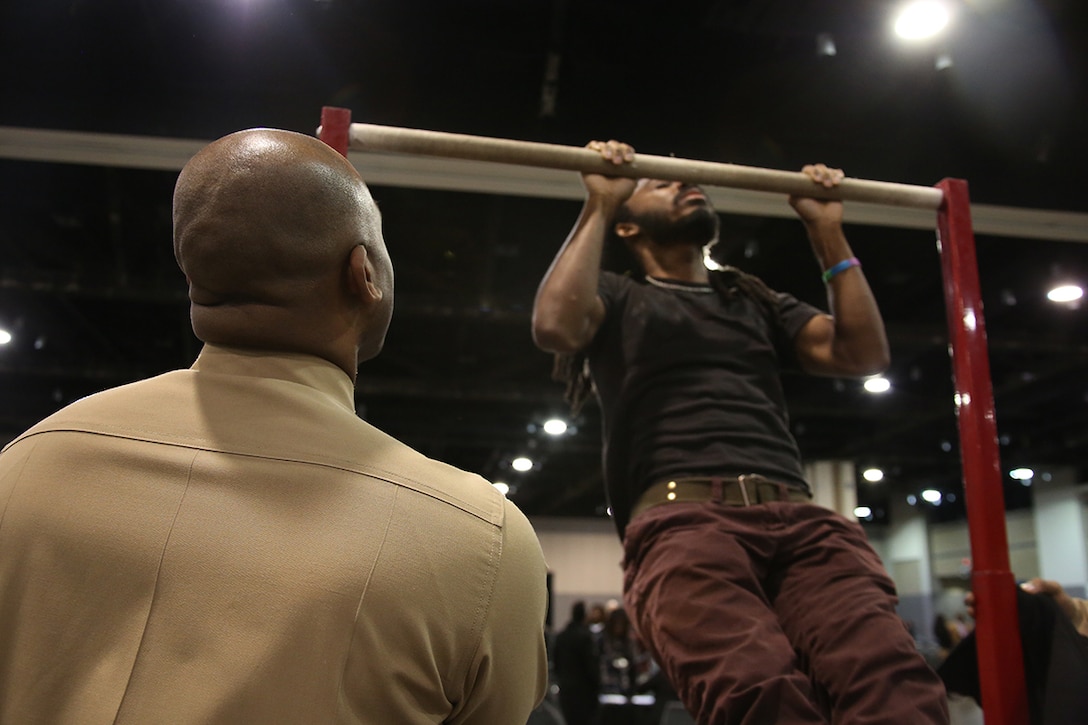 Sgt. Joe Randall watches on as a student performs pull-ups during the Central Intercollegiate Athletic Association (CIAA) High School Education Day at the Charlotte Convention Center on Feb. 25, 2015. The Marines participated in the Education Day to increase awareness of opportunities within Marine Corps Officer and Enlisted programs in an effort to further strengthen the diversity of the Corps. (Official Marine Corps Photo by Cpl. John-Paul Imbody)