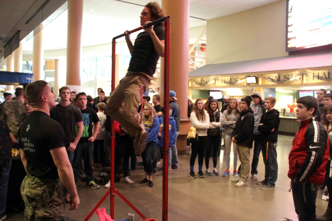 Sgt. Richard Skates, a recruiter with Marine Corps Recruiting Station Twin Cities, motivates a wrestler conducting pull ups with the United States Marines, before his competition during the Minnesota High School Wrestling Tournament held at the Excel Energy Center, February 26. 