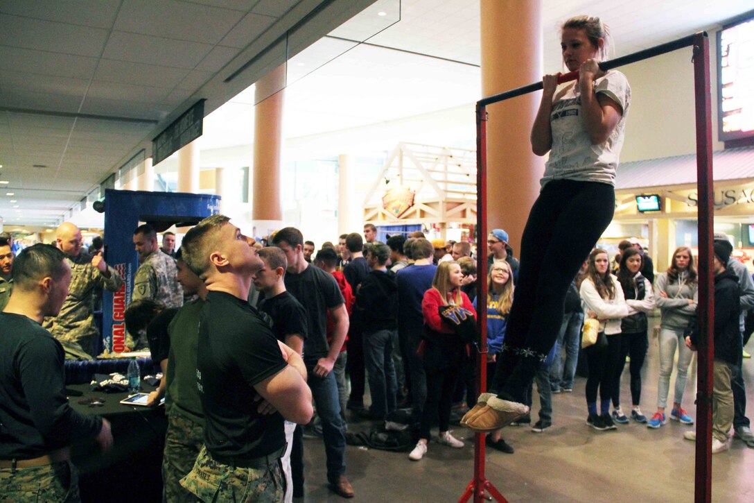 Sgt. Richard Skates, a recruiter with Marine Corps Recruiting Station Twin Cities, motivates a wrestling fan conducting a flexed arm-hang, with the United States Marines, before the next competition at the Minnesota High School Wrestling Tournament held at the Excel Energy Center, February 26. 
