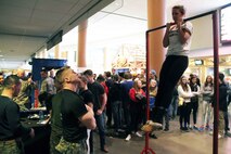Sgt. Richard Skates, a recruiter with Marine Corps Recruiting Station Twin Cities, motivates a wrestling fan conducting a flexed arm-hang, with the United States Marines, before the next competition at the Minnesota High School Wrestling Tournament held at the Excel Energy Center, February 26. 
