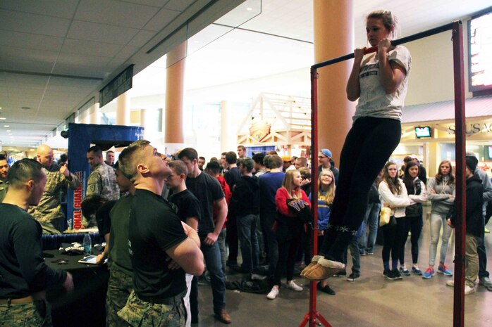 Sgt. Richard Skates, a recruiter with Marine Corps Recruiting Station Twin Cities, motivates a wrestling fan conducting a flexed arm-hang, with the United States Marines, before the next competition at the Minnesota High School Wrestling Tournament held at the Excel Energy Center, February 26. 