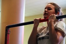 A high school wrestling fan holds herself above the bar, as long as she can, during a flexed arm-hang with the United States Marine Corps, during the Minnesota High School Wrestling Tournament held at the Excel Energy Center, February 26. 