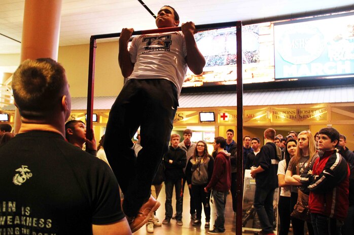 Sgt. Richard Skates, a recruiter with Marine Corps Recruiting Station Twin Cities, motivates a wrestler conducting pull ups with the United States Marines, before his competition during the Minnesota High School Wrestling Tournament held at the Excel Energy Center, February 26. 