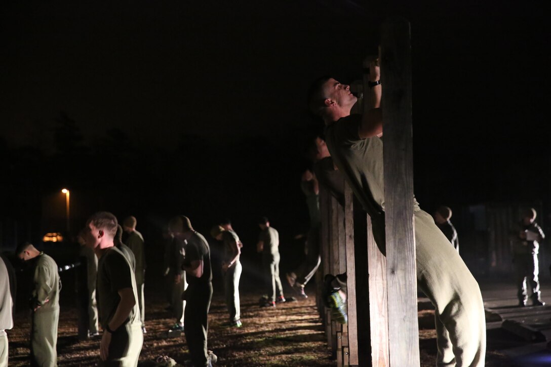 Marine perform pull-ups during Phase I of the U.S. Marine Corps Forces Special Operations Command's Assessment and Selection course aboard Marine Corps Base Camp Lejeune, N.C., Jan. 5, 2015. Completing a physical fitness test with a minimum score of 225 is a requirement to become a Critical Skills Operator with MARSOC.