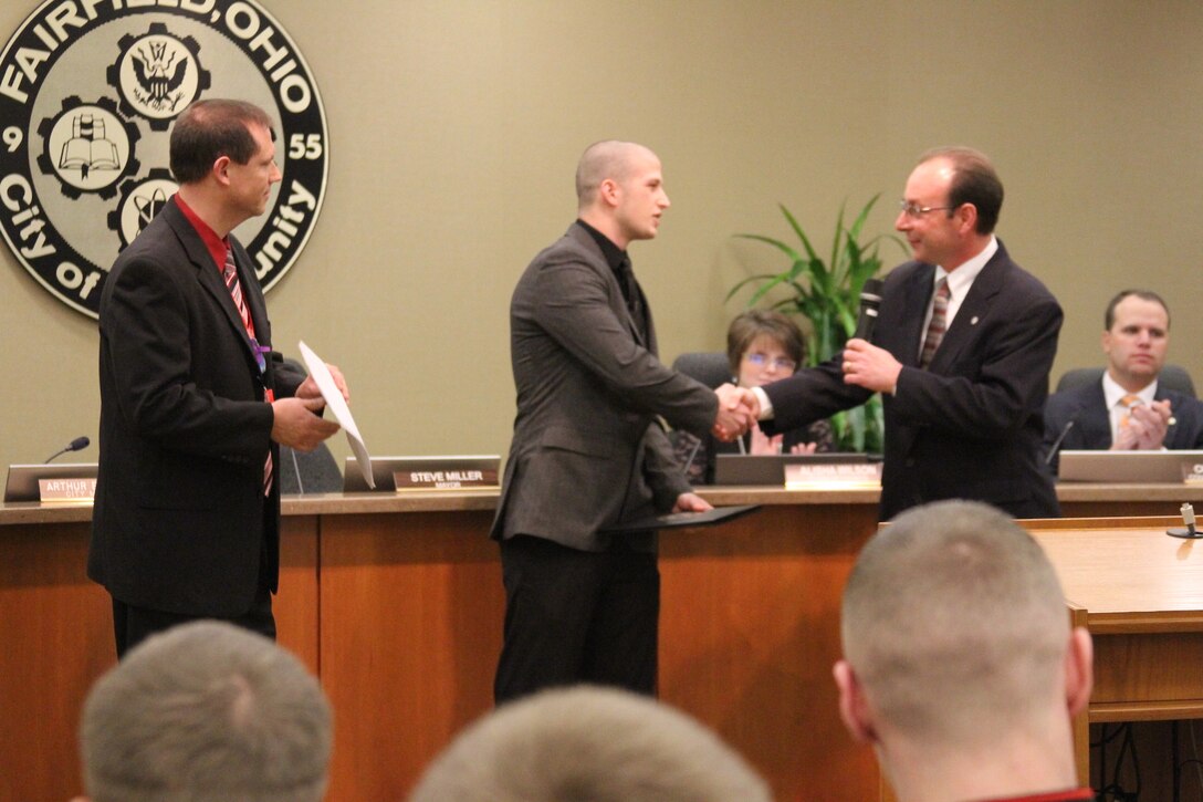 Fairfield City Council and Mayor Steve Miller (right) thanks John Jones (center), an 18-year-old Fairfield High School senior, during a Fairfield city council meeting, Jan 9, for saving the life of a substitute teacher who had collapsed in class.  After the council proclaimed the day as “John Jones Day,” Jones participated in a ceremonial oath of enlistment to join the United States Marine Corps. (Marine Corps photo by Sgt. Jennifer Pirante/Released)