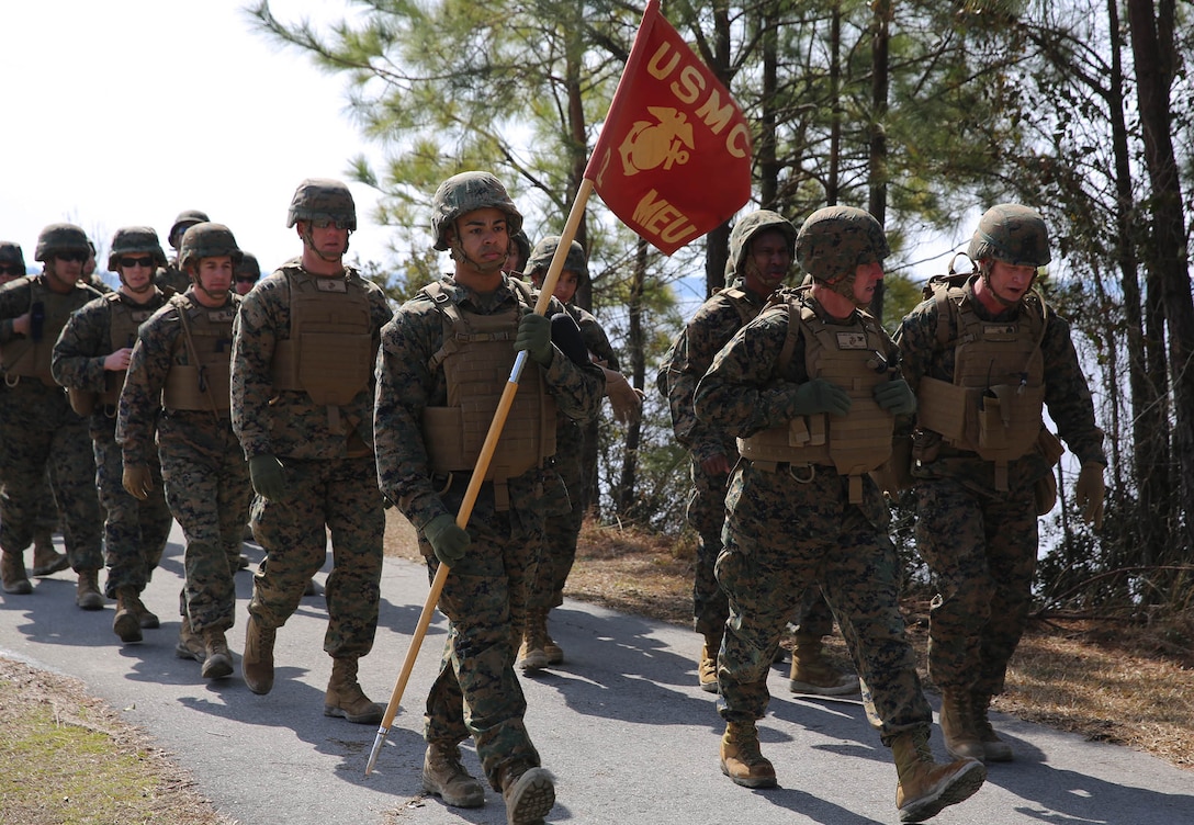 U.S. Marine Corps Sgt. Samuel Mosley, 22nd Marine Expeditionary Unit (MEU) fiscal chief and native of Devers, Texas, carries the unit guideon during a seven-mile hike at Marine Corps Base Camp Lejeune, N.C., Feb. 27, 2015. The unit conducted the hike to maintain unit readiness and build morale. (U.S. Marine Corps photo by Cpl. Caleb McDonald/Released)