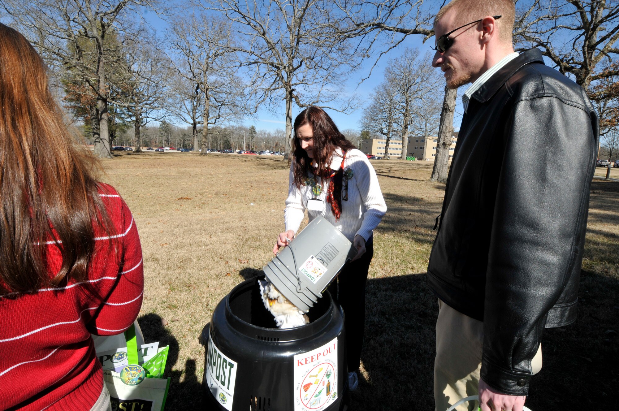 Annie Clements (center), with the ATA Information Technology and Systems Department, demonstrates how the new Earth Machine compost bins operate to Green Team members. She empties her personal compost into a bin located at the Carroll building and purchased through the Compost at AEDC Innovation Grant. Pictured with Clements are AEDC employees Donna Spry (left) and Craig Morris. (Photo by Jaqueline Cowan)