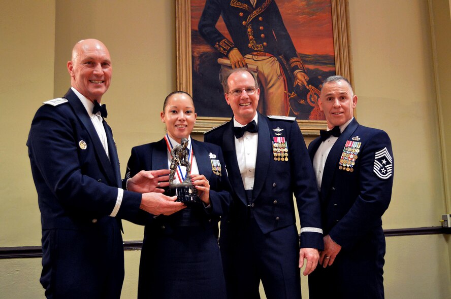 Maj. Gen. Timothy Zadalis, 618th Air Operations Center commander, presents the 440th Airlift Wing’s 2014 Senior Noncommissioned Officer of the Year Iron Mike trophy to Master Sgt. Karanda Johnson, 440th Operations Support Squadron, with Brig. Gen. James Scanlan, 440th Airlift Wing commander and Command Chief Master Sgt. Rocky Hart, 440th Airlift Wing command chief, during the 440th Airlift Wing and 43rd Airlift Group 2014 Annual Awards Banquet held at the Fort Bragg Club, Feb. 21, Fort Bragg, N.C. (U.S. Air Force photo/Marvin Krause)