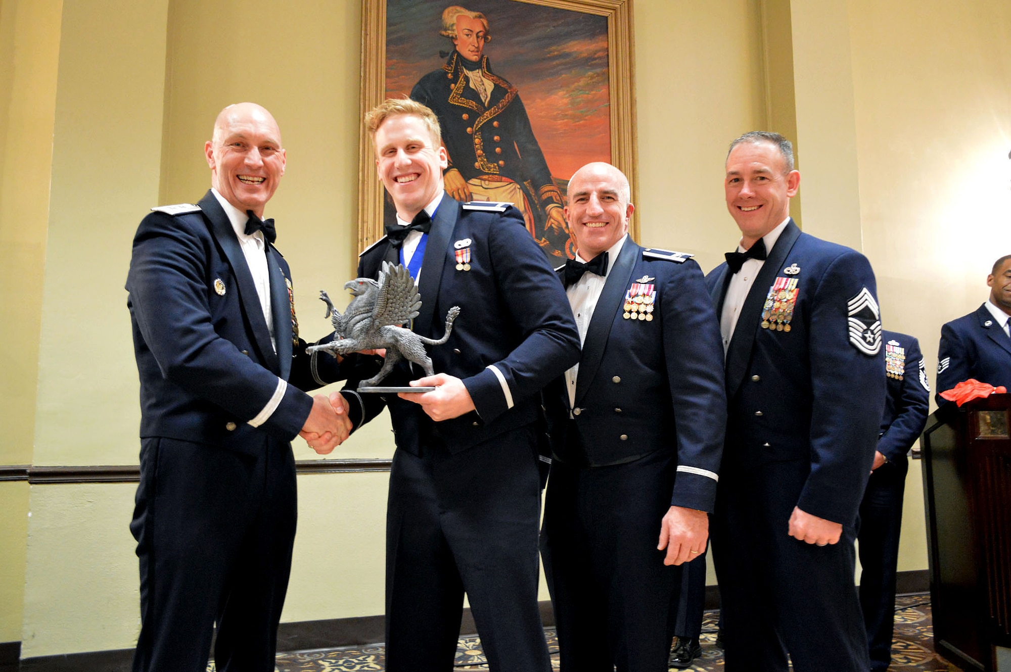 Maj. Gen. Timothy Zadalis, 618th Air Operations Center commander, presents the 43rd Airlift Group’s 2014 Company Grade Officer of the Year Gryphon trophy to Lt. Harry Kehs, 3rd Aerial Port Squadron, with Col. Kenneth Moss, 43rd Airlift Group commander and Chief Master Sgt. James Cope, 43rd Airlift Group superintendent, during the 440th Airlift Wing and 43rd Airlift Group 2014 Annual Awards Banquet held at the Fort Bragg Club, Feb. 21, Fort Bragg, N.C. (U.S. Air Force photo/Marvin Krause)
