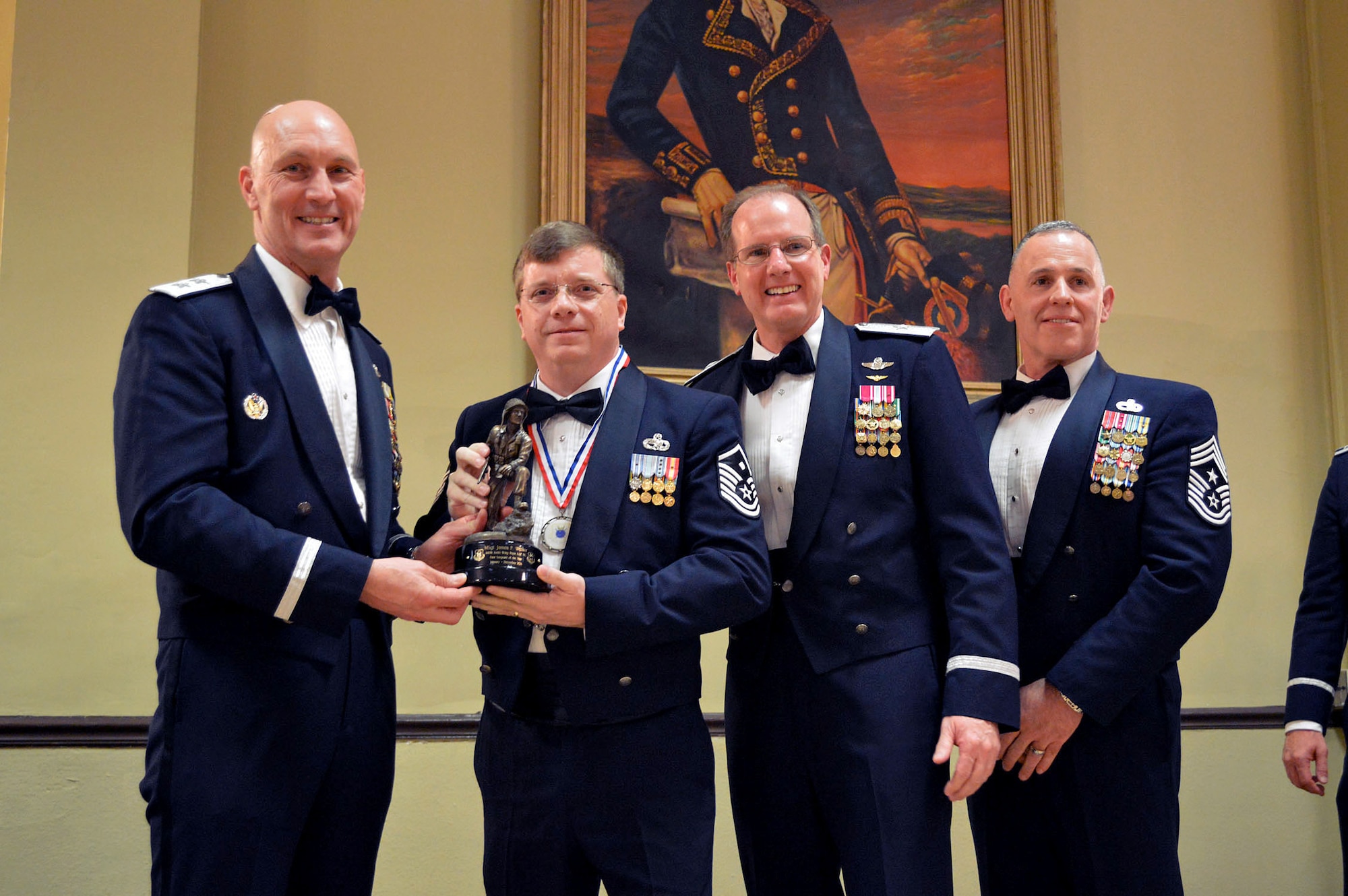 Maj. Gen. Timothy Zadalis, 618th Air Operations Center commander, presents the 440th Airlift Wing’s 2014 First Sergeant of the Year Iron Mike trophy to Master Sgt. James Walker, 440th Force Support Squadron, with Brig. Gen. James Scanlan, 440th Airlift Wing commander and Command Chief Master Sgt. Rocky Hart, 440th Airlift Wing command chief, during the 440th Airlift Wing and 43rd Airlift Group 2014 Annual Awards Banquet held at the Fort Bragg Club, Feb. 21, Fort Bragg, N.C. (U.S. Air Force photo/Marvin Krause)
