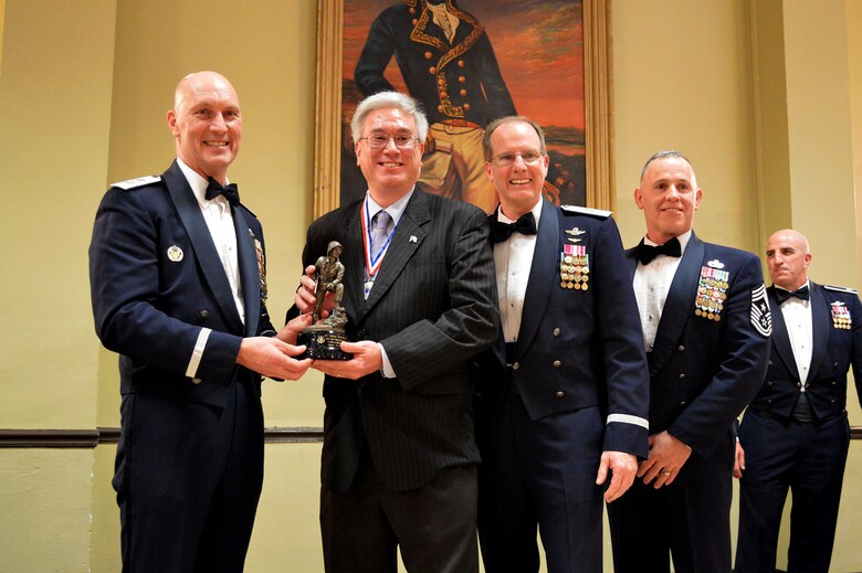 Maj. Gen. Timothy Zadalis, 618th Air Operations Center commander, presents the 440th Airlift Wing’s 2014 Civilian of the Year, Category I, Iron Mike trophy to Danny Schneeweis, 440th Operations Support Squadron, with Brig. Gen. James Scanlan, 440th Airlift Wing commander and Command Chief Master Sgt. Rocky Hart, 440th Airlift Wing command chief, during the 440th Airlift Wing and 43rd Airlift Group 2014 Annual Awards Banquet held at the Fort Bragg Club, Feb. 21, Fort Bragg, N.C. while Col. Kenneth Moss, 43rd Airlift Group commander, looks on. (U.S. Air Force photo/Marvin Krause)