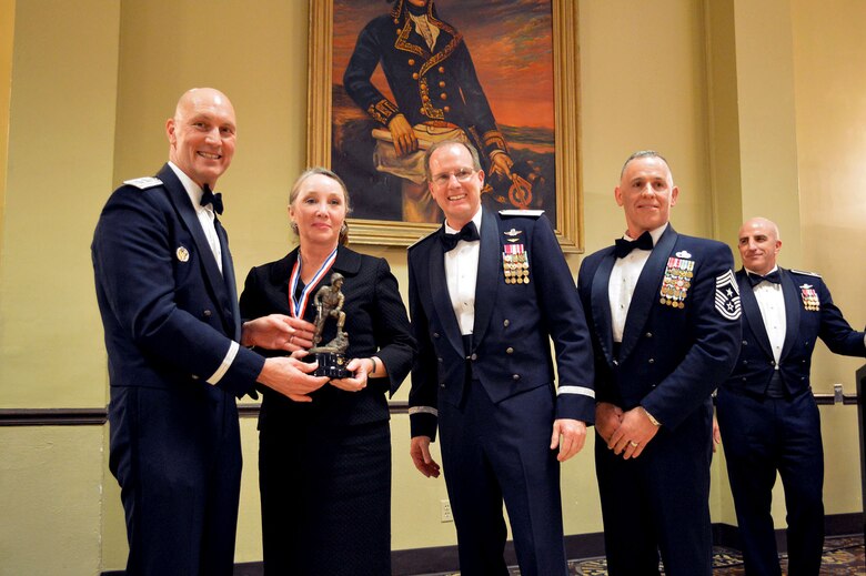 Maj. Gen. Timothy Zadalis, 618th Air Operations Center commander, presents the 440th Airlift Wing’s 2014 Civilian of the Year, Category II, Iron Mike trophy to Elizabeth Upton, 440th Airlift Wing, with Brig. Gen. James Scanlan, 440th Airlift Wing commander and Command Chief Master Sgt. Rocky Hart, 440th Airlift Wing command chief, during the 440th Airlift Wing and 43rd Airlift Group 2014 Annual Awards Banquet held at the Fort Bragg Club, Feb. 21, Fort Bragg, N.C. while Col. Kenneth Moss, 43rd Airlift Group commander, looks on. (U.S. Air Force photo/Marvin Krause)