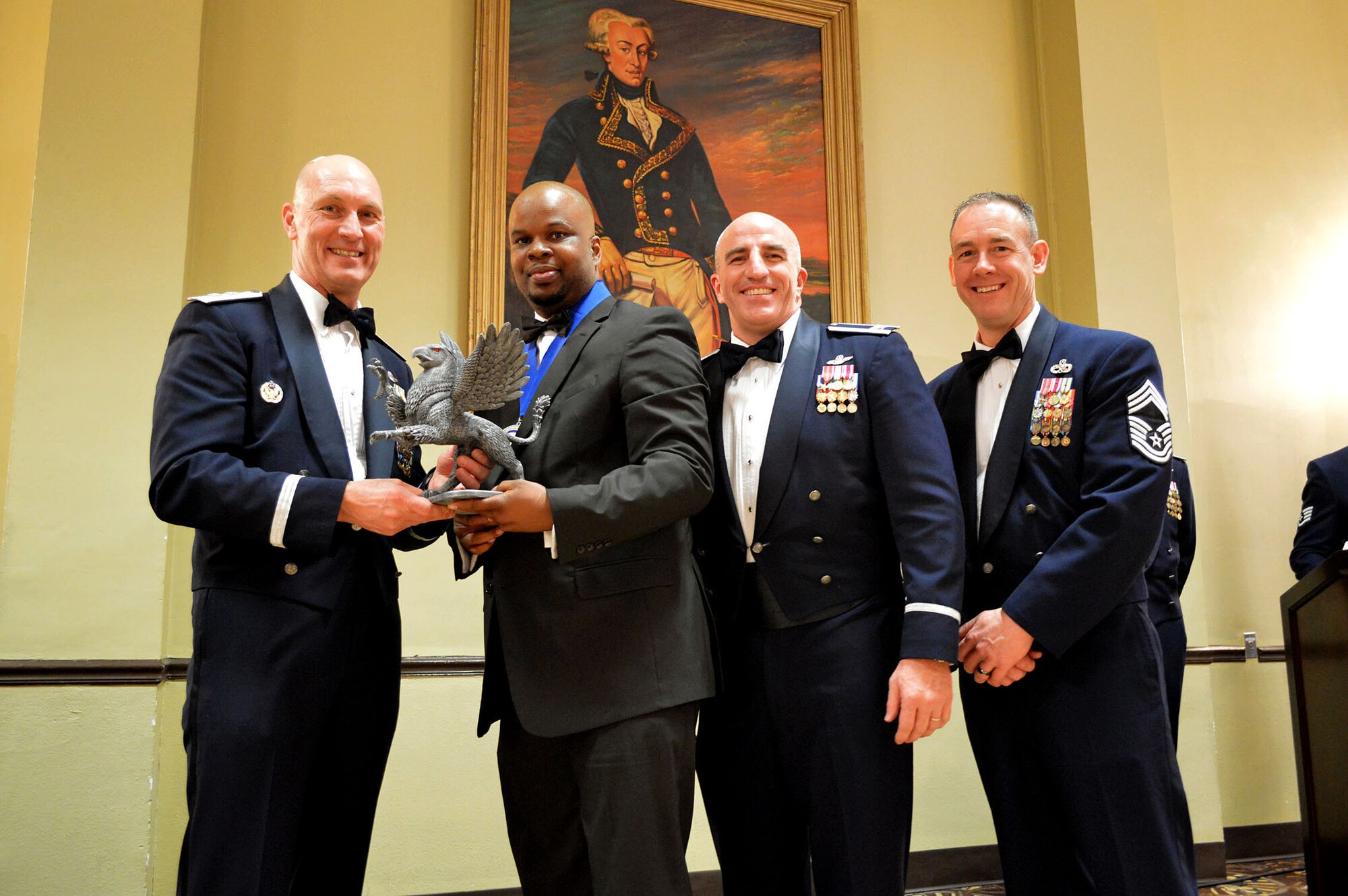 Maj. Gen. Timothy Zadalis, 618th Air Operations Center commander, presents the 43rd Airlift Group’s 2014 Civilian of the Year, Category II, Gryphon trophy to Benjamin Anderson, 43rd Force Support Squadron with Col. Kenneth Moss, 43rd Airlift Group commander and Chief Master Sgt. James Cope, 43rd Airlift Group superintendent, during the 440th Airlift Wing and 43rd Airlift Group 2014 Annual Awards Banquet held at the Fort Bragg Club, Feb. 21, Fort Bragg, N.C. (U.S. Air Force photo/Marvin Krause)