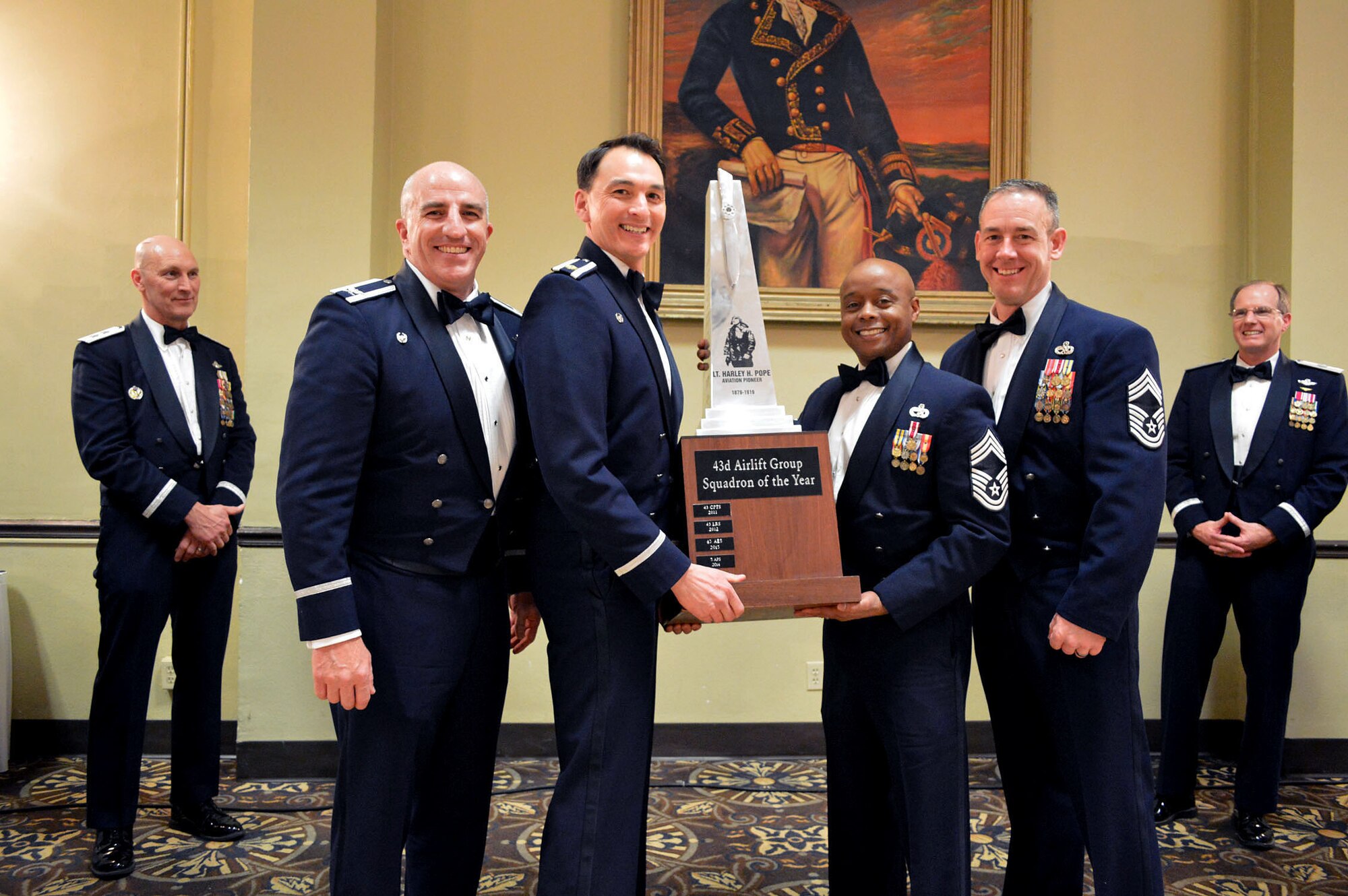 Col. Kenneth Moss, 43rd Airlift Group commander and Chief Master Sgt. James Cope, 43rd Airlift Group superintendent, present the 43rd Airlift Group’s 2014 Squadron of the Year trophy to Maj. Joseph Whittington, 3rd Aerial Port Squadron commander and Chief Master Sgt. Kenneth Hubbard, 3rd Aerial Port Squadron superintendent, recognizing the 3rd Aerial Port Squadron as the best unit in the group for 2014 while Maj. Gen. Timothy Zadalis, 618th Air Operations Center commander and Brig. Gen James Scanlan, 440th Airlift Wing commander look on. (U.S. Air Force photo/Marvin Krause)