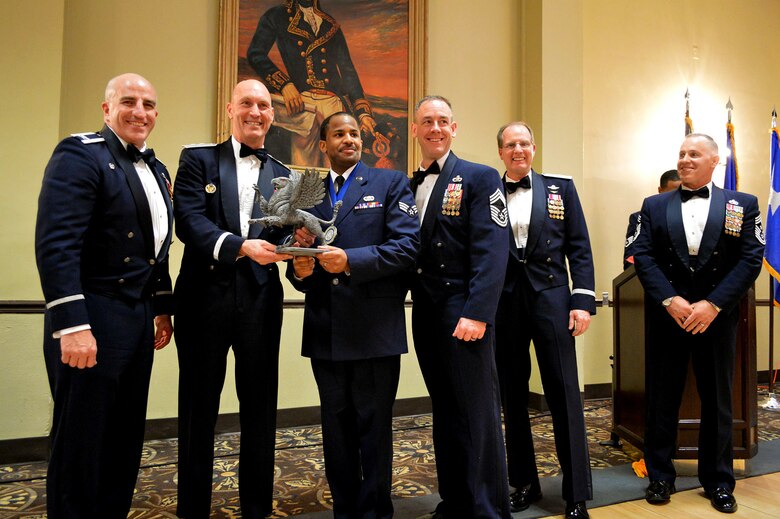 Maj. Gen. Timothy Zadalis, 618th Air Operations Center commander, presents the 43rd Airlift Group’s 2014 Airman of the Year Gryphon trophy to Senior Airman Earl Brown, 43rd Logistics Readiness Squadron with Col. Kenneth Moss, 43rd Airlift Group commander and Chief Master Sgt. James Cope, 43rd Airlift Group superintendent, during the 440th Airlift Wing and 43rd Airlift Group 2014 Annual Awards Banquet held at the Fort Bragg Club, Feb. 21, Fort Bragg, N.C. with Brig. Gen James Scanlan, 440th Airlift Wing commander and Command Chief Master Sgt. Rocky Hart, 440th Airlift Wing command chief, look on. (U.S. Air Force photo/Marvin Krause)