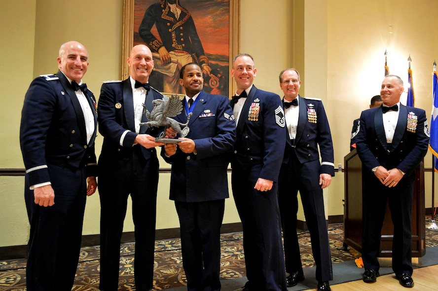 Maj. Gen. Timothy Zadalis, 618th Air Operations Center commander, presents the 43rd Airlift Group’s 2014 Airman of the Year Gryphon trophy to Senior Airman Earl Brown, 43rd Logistics Readiness Squadron with Col. Kenneth Moss, 43rd Airlift Group commander and Chief Master Sgt. James Cope, 43rd Airlift Group superintendent, during the 440th Airlift Wing and 43rd Airlift Group 2014 Annual Awards Banquet held at the Fort Bragg Club, Feb. 21, Fort Bragg, N.C. with Brig. Gen James Scanlan, 440th Airlift Wing commander and Command Chief Master Sgt. Rocky Hart, 440th Airlift Wing command chief, look on. (U.S. Air Force photo/Marvin Krause)