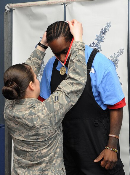 Airman 1st Class Cassandra Heal awards a gold medal to a competitor after competing at the D.C. Special Olympics Bowling Championship Feb. 25, 2015, in Hyattsville, Md. Every year athletes from the across the National Capital Region compete in the four-day championship competition. Heal works as a Bio Medical Equipment Technician for the 779th Medical Group, Joint Base Andrews. (U.S. Air Force photo/James E. Lotz)