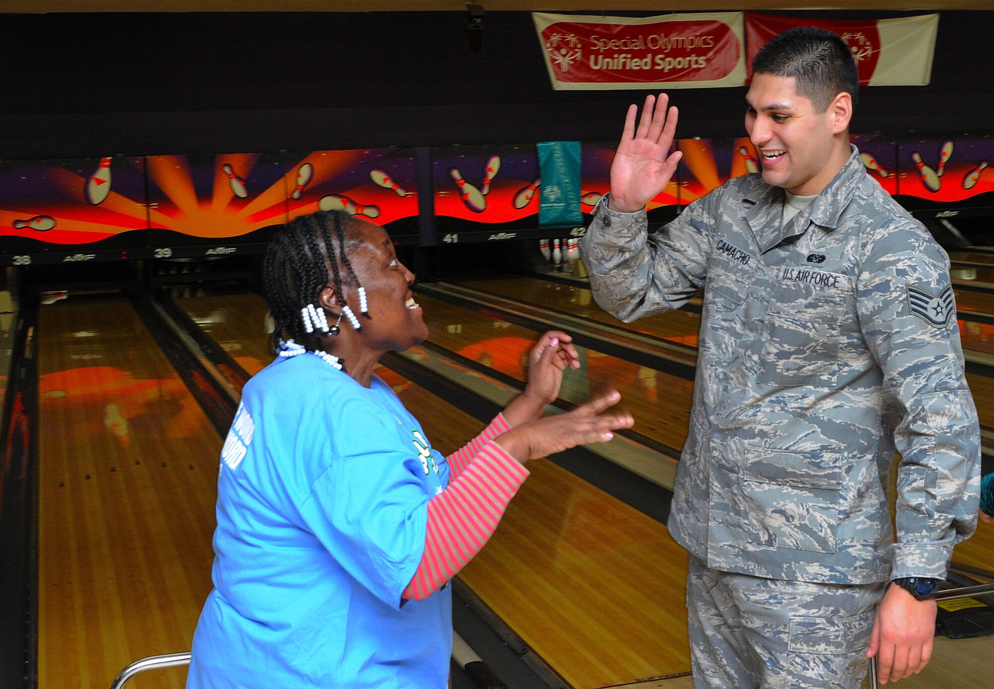Staff Sgt. Jose Camacho congratulates a competitor after picking up a spare at the D.C. Special Olympics Bowling Championship Feb. 25, 2015, in Hyattsville, Md. Every year athletes from the across the National Capital Region compete in the four-day championship competition. Camacho works as a Paralegal/Civil Litigation for the Air Force Legal Operation Agency (AFLOA), Joint Base Andrews. (U.S. Air Force photo/James E. Lotz)
