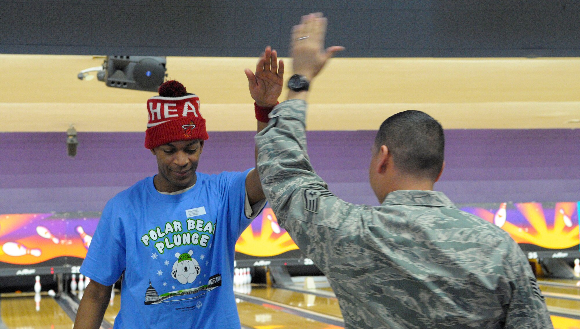 Staff Sgt. Daniel Andrade, 11th Security Support Squadron, congratulates athlete Daniel Hutto with a high-five at the D.C. Special Olympics Bowling Championship in Hyattsville, Md., Feb. 25, 2015. Air Force District of Washington Airmen hosted one of four days of competition for the annual D.C. Special Olympics Bowling Championship. (U.S. Air Force photo/Michael Martin)