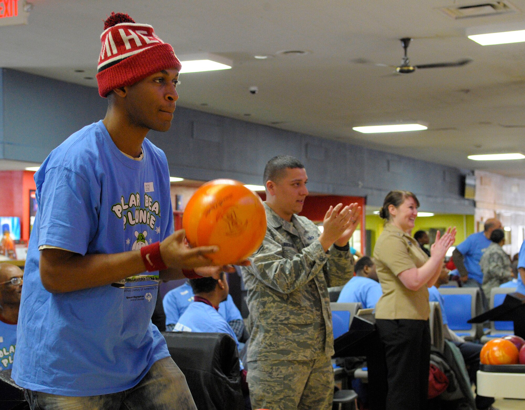 Athlete Daniel Hutto focuses on the bowling pins ahead as service members cheer on his fellow competitors at the D.C. Special Olympics Bowling Championship Feb. 25, 2015, in Hyattsville, Md.  Joint Base Andrews Airmen, along with members from each service, volunteered to support Special Olympic athletes from across the National Capital Region compete in the event. (U.S. Air Force photo/Michael Martin)