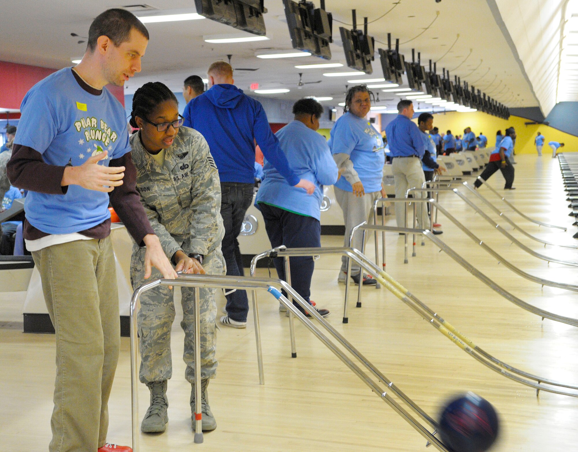 Staff Sgt. Connecticut Wilson, 89th Airlift Wing flight attendant, assists D.C. Special Olympics Bowling Championship competitor Christopher McClain at the bowling tournament Feb. 25, 2015, in Hyattsville, Md.  More than 50 Airmen from across the National Capital Region volunteered to support athletes competing in the event. (U.S. Air Force photo/Michael Martin)