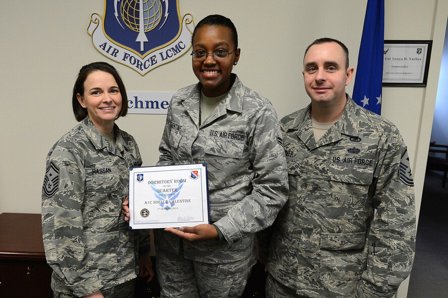 Airman 1st Class Noelle Valentine, Air Force Life Cycle Management Center Detachment 7 unit deployment manager, poses for a picture with Senior Master Sgt. Pattie Hassan, AFLCMC first sergeant, and Master Sgt. Jason Oliver, 66th Medical Squadron first sergeant, after receiving the Dormitory Room of the Quarter award during a presentation Feb. 26. The dormitory rooms are inspected for deficiencies by Hanscom first sergeants. (U.S. Air Force photo by Jerry Saslav)