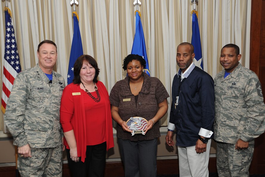Air Force District of Washington Commander Maj. Gen. Darryl Burke and Command Chief Master Sgt. Farrell Thomas present the Smart Conference Center Team with the Headquarters AFDW Annual Award Team of the Year trophy at Joint Base Andrews, Md. The Smart Conference Center Team executed 200 conferences and accommodated more than 11,000 customers including the U.S. President. (U.S. Air Force photo/James E. Lotz) 