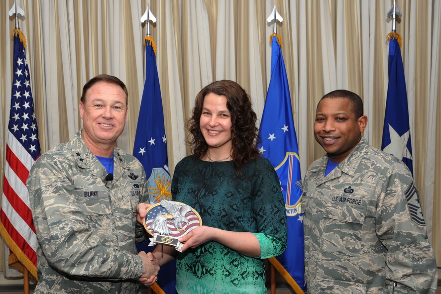 Air Force District of Washington Commander Maj. Gen. Darryl Burke and Command Chief Master Sgt. Farrell Thomas present Patricia Gray with the Headquarters AFDW Annual Award Civilian Category III of the Year trophy at Joint Base Andrews, Md. Gray is assigned to the AFDW Logistics, Installations, and Mission Support  directorate. During 2014 Gray facilitated the AFDW Council’s approval of $29 million in operations and management priority projects. (U.S. Air Force photo/James E. Lotz) 