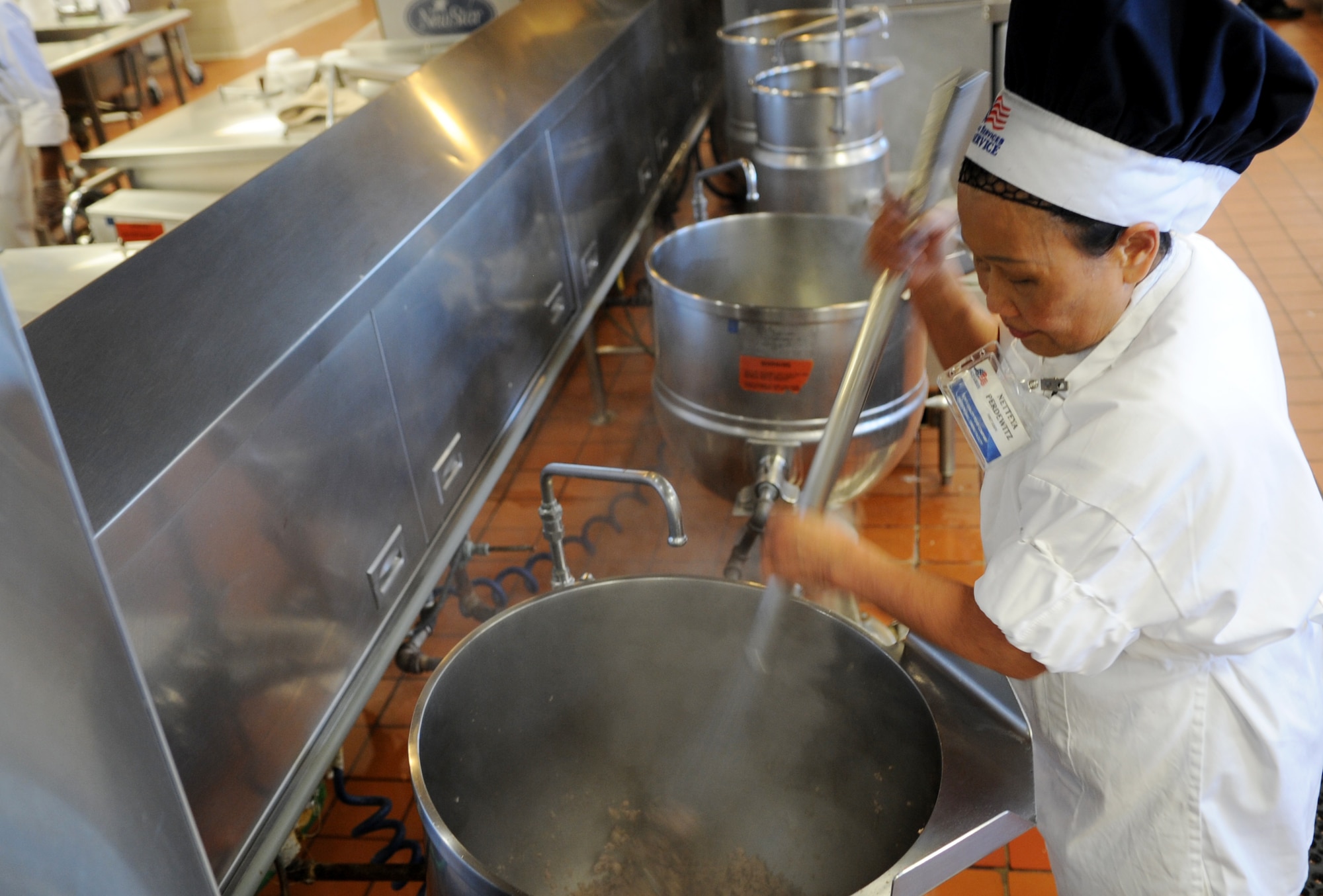 Netteya Perdewttz, Son's Quality Food first cook, prepares for lunch service during the Hennessey Award Trophy evaluation at Freedom Hall Dining Facility on Joint Base Andrews, Md., Feb. 20, 2015. (U.S. Air Force photo/Staff Sgt. Nichelle Anderson)
