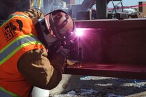 Tommy Littleben Sr., LPR construction welder, welds a steel plate to connect two beams that will hold the roof of Hangar 1126, Feb. 24, at McConnell Air Force Base, Kan. The hangar is being built in preparation for the arrival of the KC-46A Pegasus. (U.S. Air Force photo by Airman 1st Class Christopher Thornbury) 