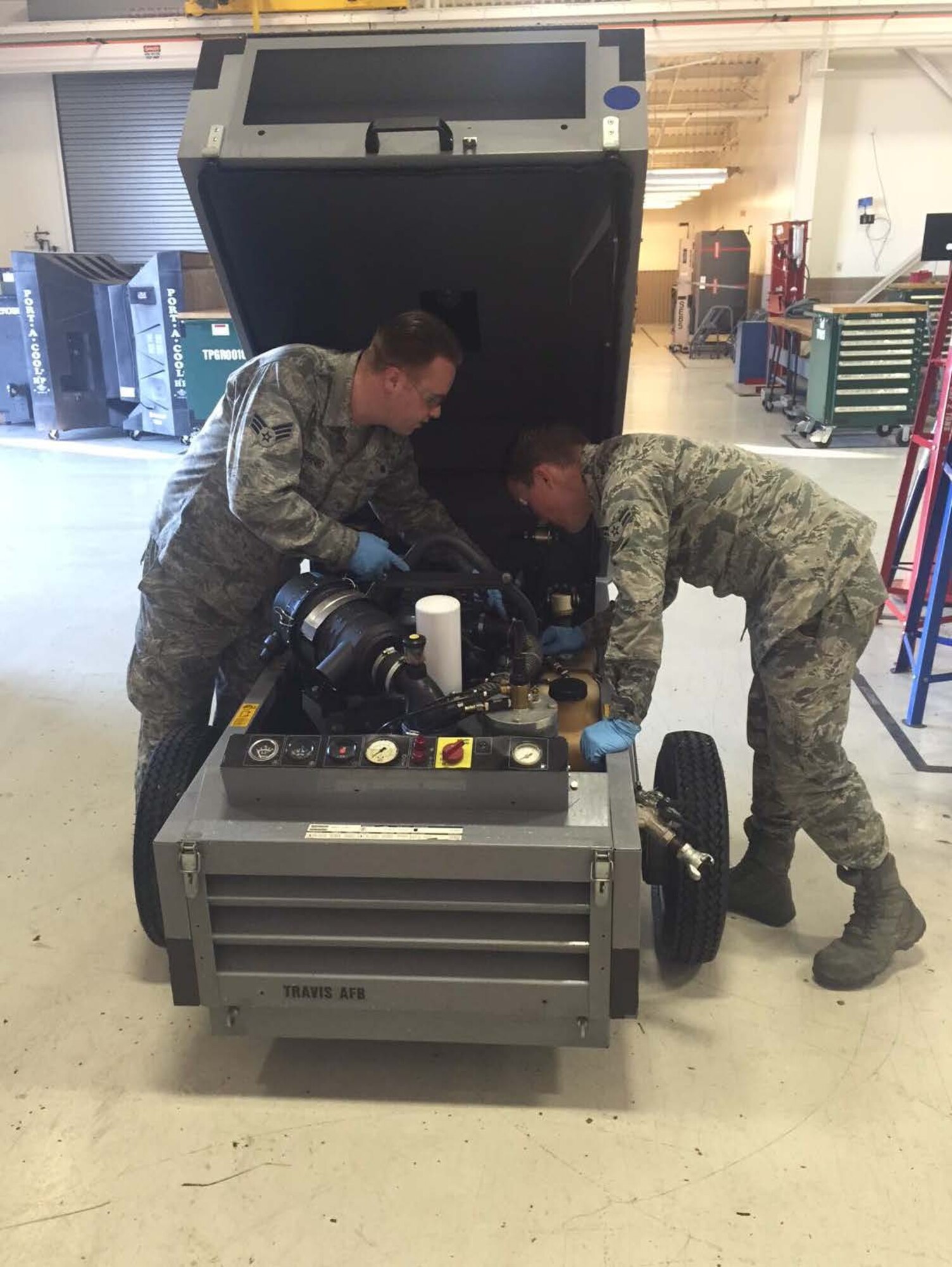 Senior Airman Thomas Ribeiro trains Airman 1st Class Mark Jett, 60th Maintenance Squadron Aerospace Ground Equipment, on a diesel-powered air compressor inspection recently at Travis Air Force Base, Calif. AGE Airmen keep track of maintenance equipment. (Courtesy photo)