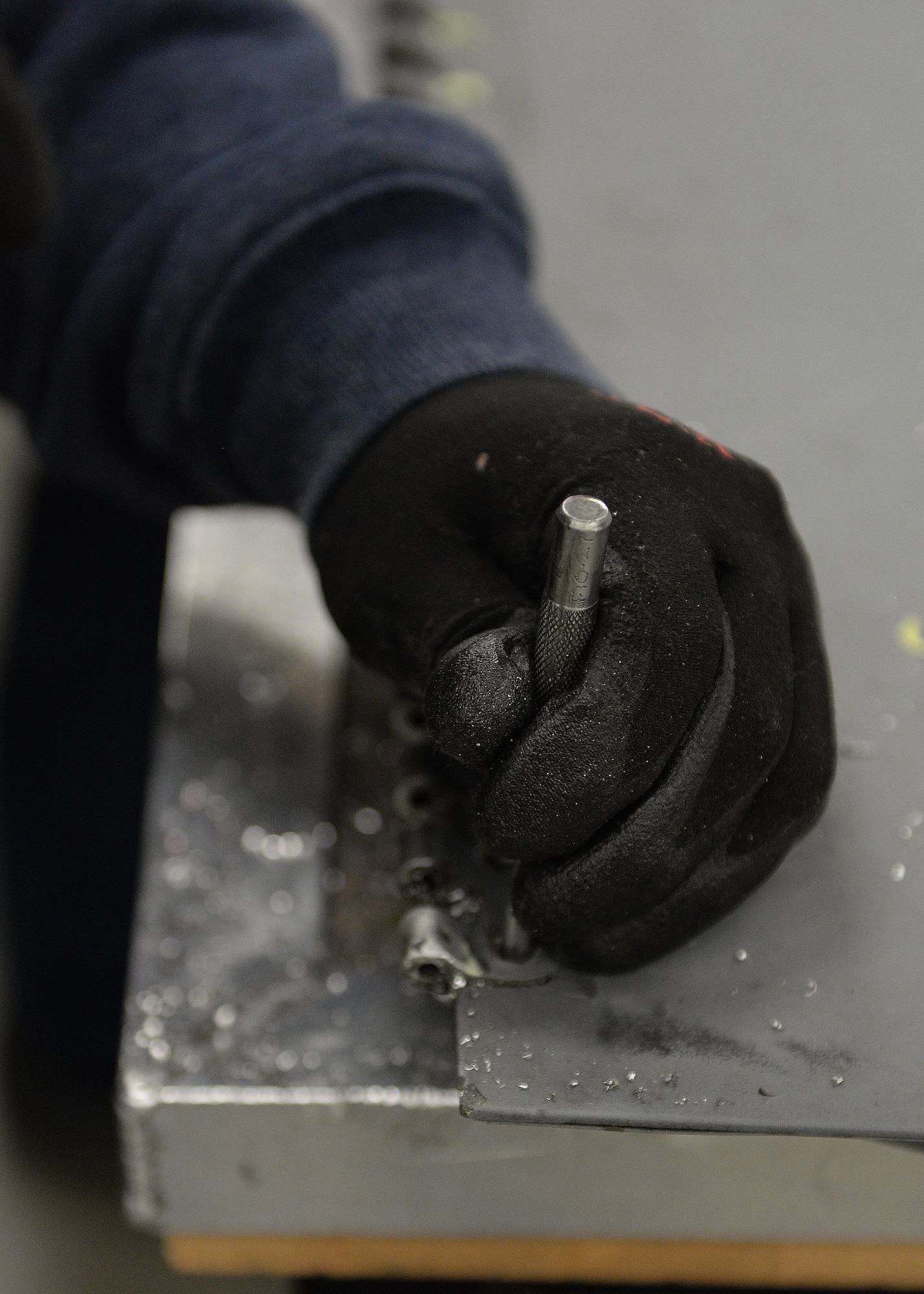ALTUS AIR FORCE BASE, Okla. – Joe Balderas, 97th Maintenance Directorate A-Team sheet metal mechanic, performs a hinge replacement on a KC-135 Stratotanker refueling aircraft main landing gear follow-up door at Hangar 517, Feb. 24, 2015. Aircraft fuselage skins and panels develop cracks and broken brackets due to normal wear and stresses. The fabrication flight performs field level repairs, sometimes even fabricating parts in the shop. (U.S. Air Force photo by Airman 1st Class Megan E. Acs/Released)