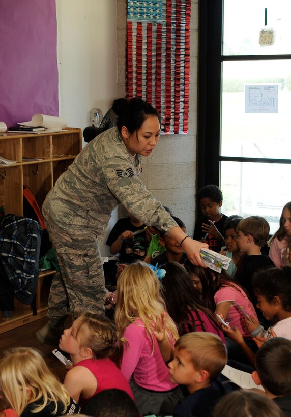 Tech. Sgt. Jessica Chang, 30th Medical Operations Squadron dental technician, distributes toothbrushes to children from the Youth Center, Feb. 18, 2015, Vandenberg Air Force Base, Calif. The dental flight, within the 30th MDOS, has been observing National Children’s Dental Health Month, throughout February. (U.S. Air Force photo by Senior Airman Shane Phipps/Released)